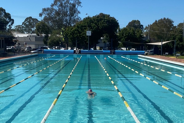 a solitary swimmer in an outdoor pool