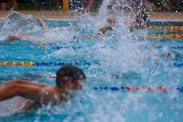 Several young swimmers compete in a butterfly race